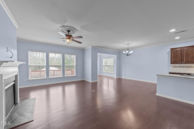 unfurnished living room with dark wood-type flooring, plenty of natural light, and crown molding