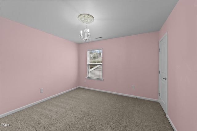 spare room with carpet floors and an inviting chandelier