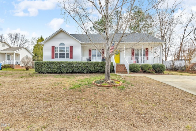 single story home featuring a porch, a front yard, and driveway