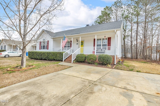 view of front of property featuring covered porch and a shingled roof