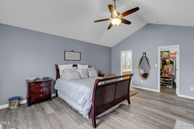 bedroom with lofted ceiling, light wood-style flooring, baseboards, a spacious closet, and a closet