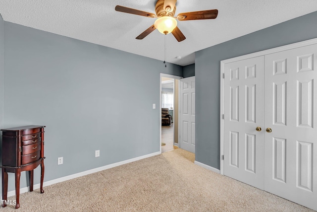 bedroom with a textured ceiling, a closet, carpet flooring, and baseboards