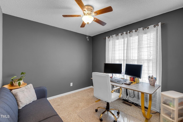 carpeted office featuring a ceiling fan, a textured ceiling, and baseboards