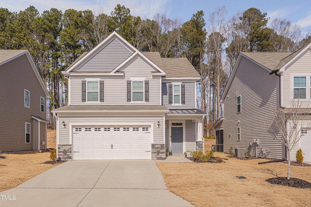 view of front of home with a garage and central air condition unit