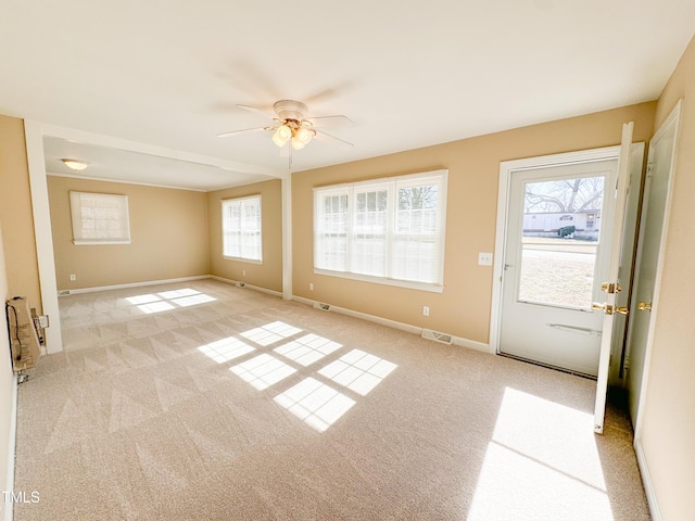 interior space featuring light carpet and ceiling fan