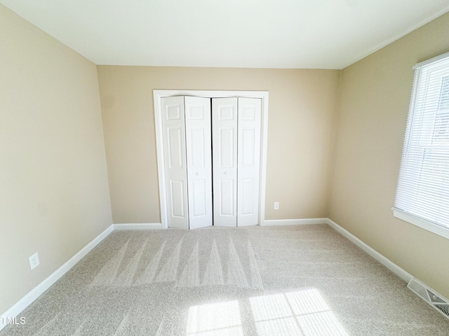 unfurnished bedroom featuring carpet and a closet