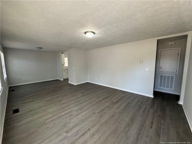 unfurnished room featuring dark hardwood / wood-style floors and a textured ceiling