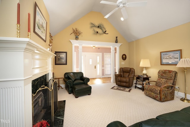 carpeted living room with ceiling fan, high vaulted ceiling, a premium fireplace, and decorative columns