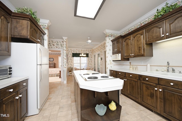 kitchen with sink, ceiling fan, dark brown cabinetry, crown molding, and white appliances