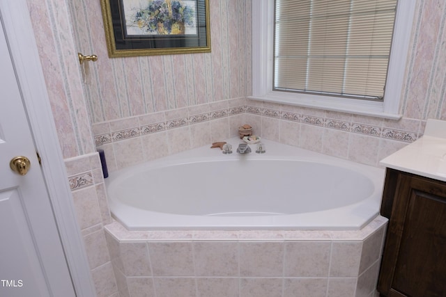 bathroom with vanity and tiled tub