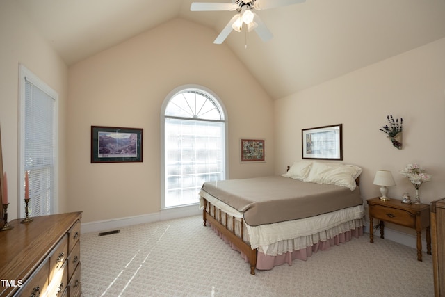 bedroom featuring multiple windows, vaulted ceiling, light carpet, and ceiling fan