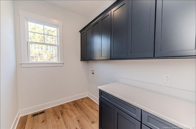 laundry area with cabinets, hookup for a washing machine, and light hardwood / wood-style flooring