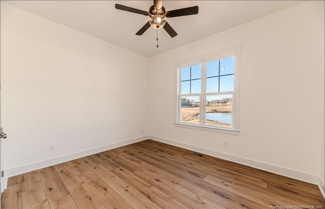 empty room with ceiling fan and light hardwood / wood-style floors