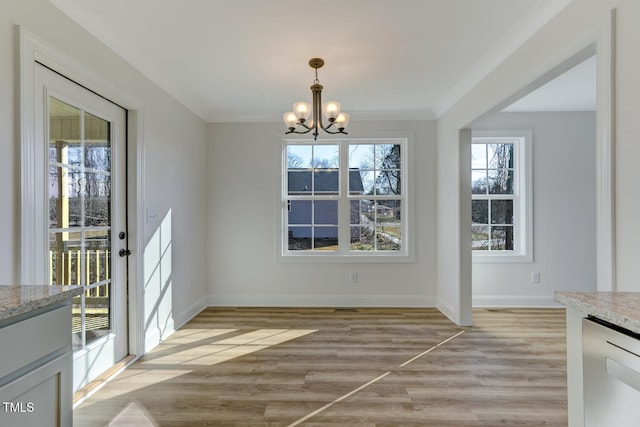 unfurnished dining area featuring a notable chandelier, light hardwood / wood-style flooring, and ornamental molding