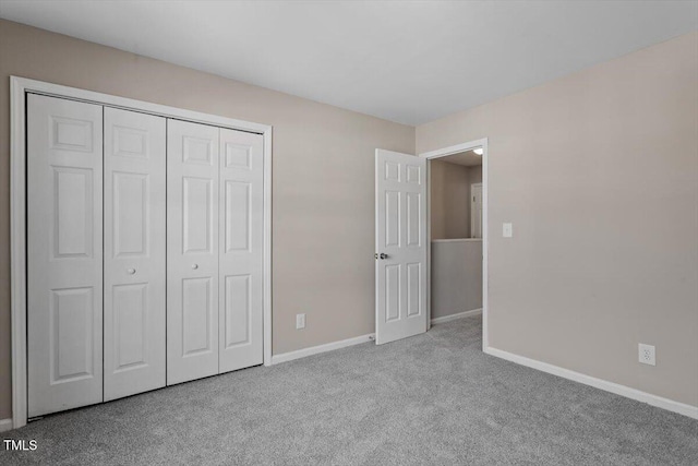 unfurnished bedroom featuring a closet and light carpet