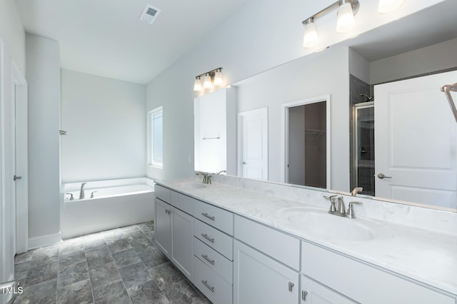 bathroom featuring vanity and independent shower and bath