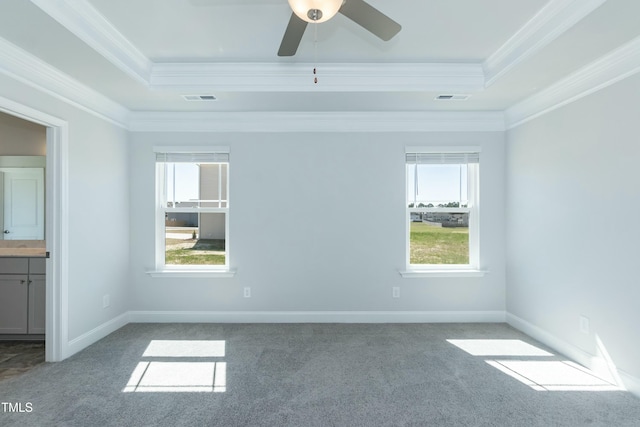 carpeted spare room featuring a tray ceiling, ornamental molding, and ceiling fan