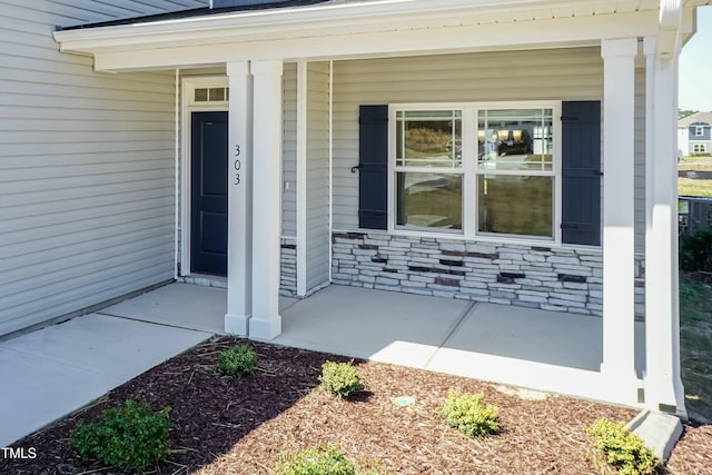 view of exterior entry featuring covered porch