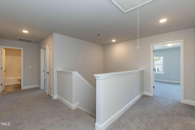 hall featuring light colored carpet