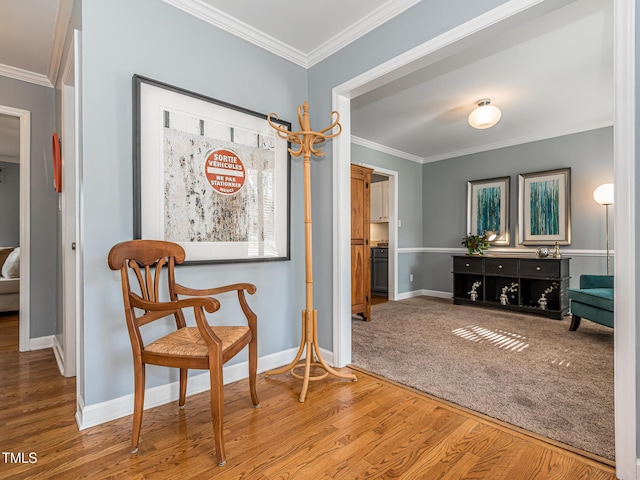 sitting room with ornamental molding, baseboards, and wood finished floors