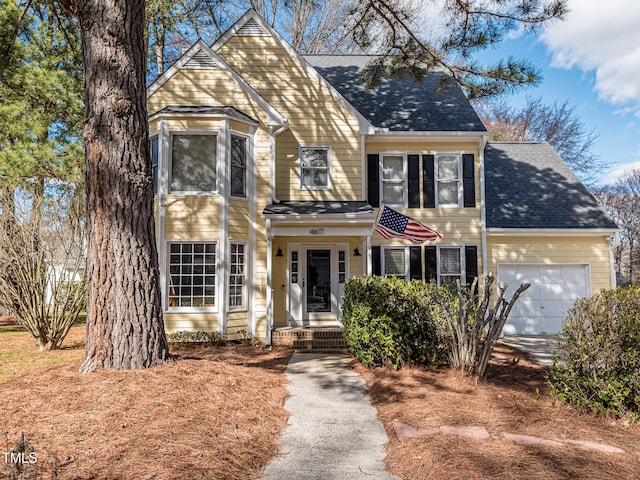 view of front of property with a garage and roof with shingles