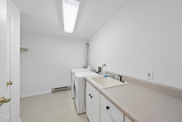 laundry area featuring cabinet space, baseboards, a baseboard radiator, washer and dryer, and a sink