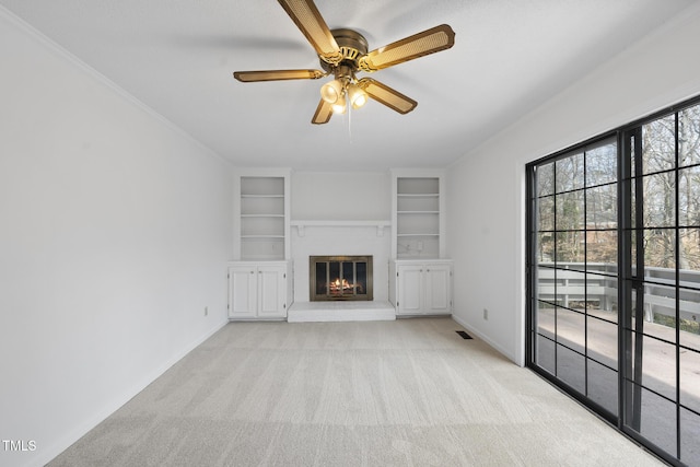 unfurnished living room featuring visible vents, baseboards, a glass covered fireplace, light colored carpet, and ceiling fan