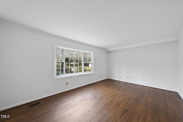 unfurnished room featuring visible vents, ornamental molding, a textured ceiling, wood finished floors, and baseboards