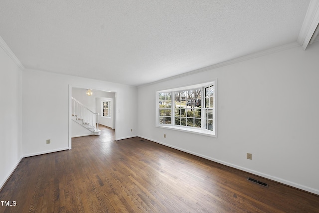 empty room featuring baseboards, stairs, visible vents, and wood finished floors