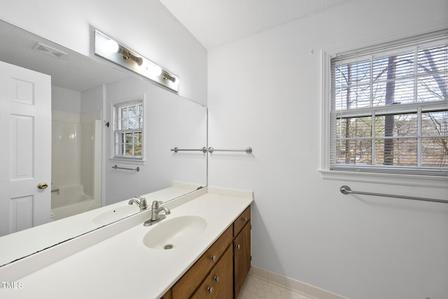 bathroom featuring a healthy amount of sunlight, visible vents, a shower, and vanity