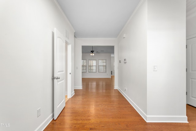 hallway with crown molding and light hardwood / wood-style flooring