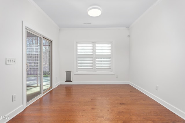 empty room featuring crown molding and wood-type flooring