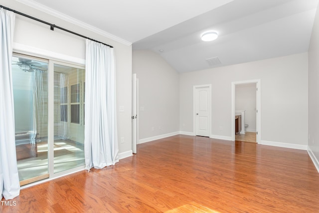 empty room featuring vaulted ceiling and light wood-type flooring