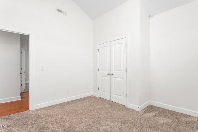 unfurnished room featuring carpet floors and high vaulted ceiling