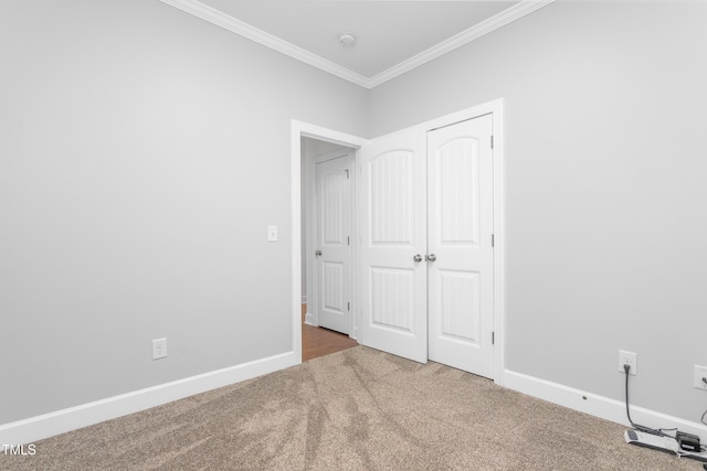 unfurnished bedroom featuring ornamental molding, carpet, and a closet