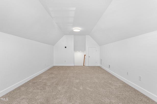 additional living space with lofted ceiling and carpet