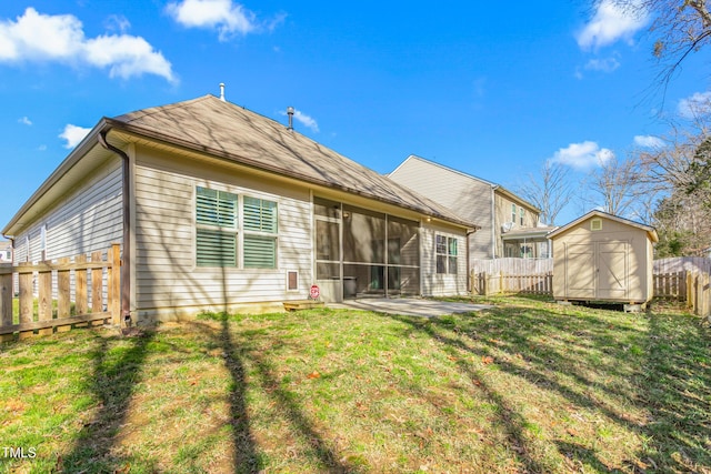 rear view of house featuring a storage shed, a sunroom, a yard, and a patio area