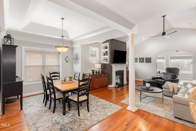 dining area featuring a wealth of natural light, light hardwood / wood-style floors, ceiling fan, and ornate columns