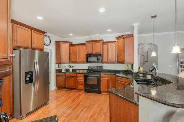 kitchen featuring sink, dark stone countertops, hanging light fixtures, black appliances, and kitchen peninsula