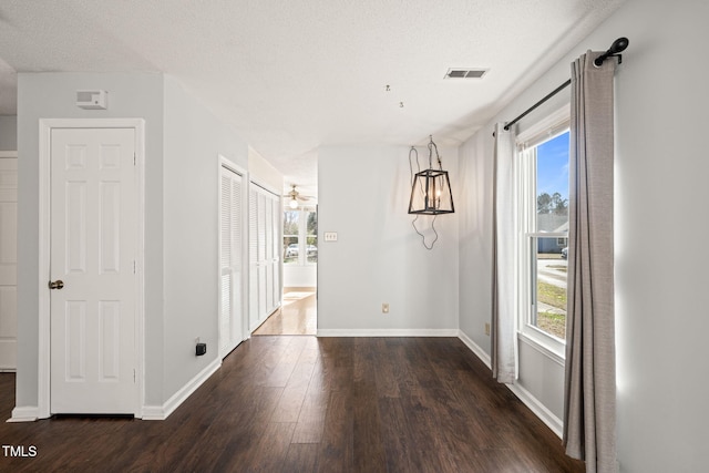 unfurnished dining area with dark hardwood / wood-style floors and a textured ceiling