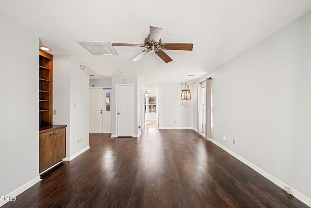 unfurnished living room featuring dark wood-type flooring, a textured ceiling, ceiling fan, and built in shelves