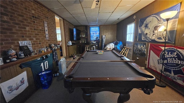 recreation room with pool table, brick wall, carpet, and a drop ceiling