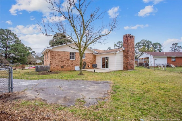 rear view of house featuring a yard, central AC, and a patio area