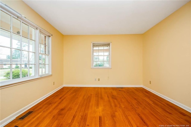 empty room featuring hardwood / wood-style flooring and a healthy amount of sunlight