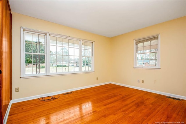 empty room featuring hardwood / wood-style flooring and a healthy amount of sunlight