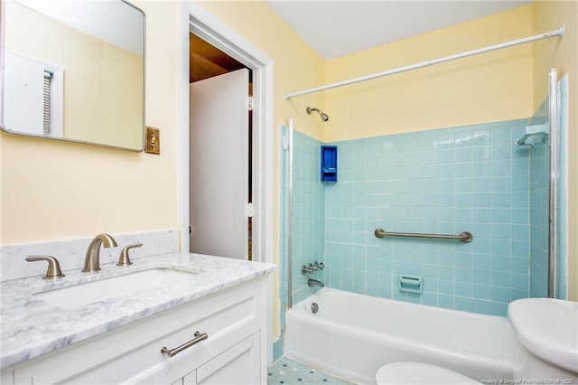 full bathroom featuring vanity, tiled shower / bath, and toilet