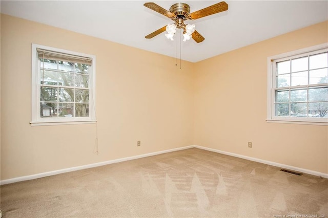 empty room with ceiling fan and light colored carpet