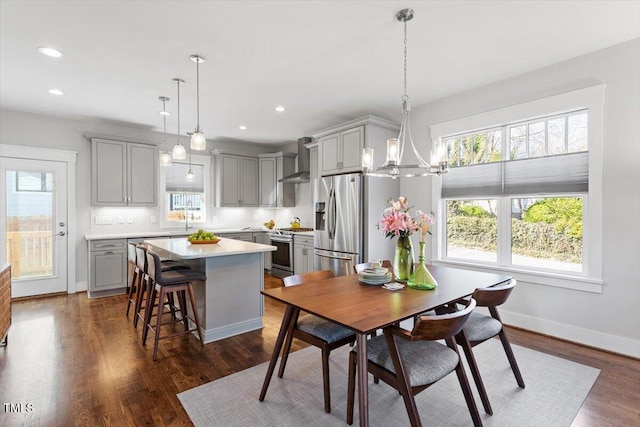 dining room with dark hardwood / wood-style flooring, sink, and an inviting chandelier