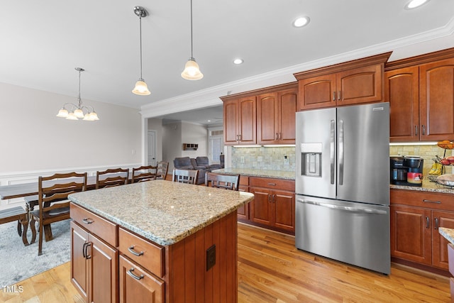 kitchen featuring light wood-type flooring, a center island, stainless steel fridge with ice dispenser, and light stone countertops