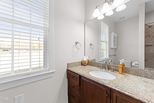 bathroom with toilet, visible vents, a wealth of natural light, and vanity